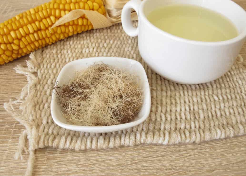 컵에 담겨 있는 옥수수수염차와 접시에 담긴 옥수수수염